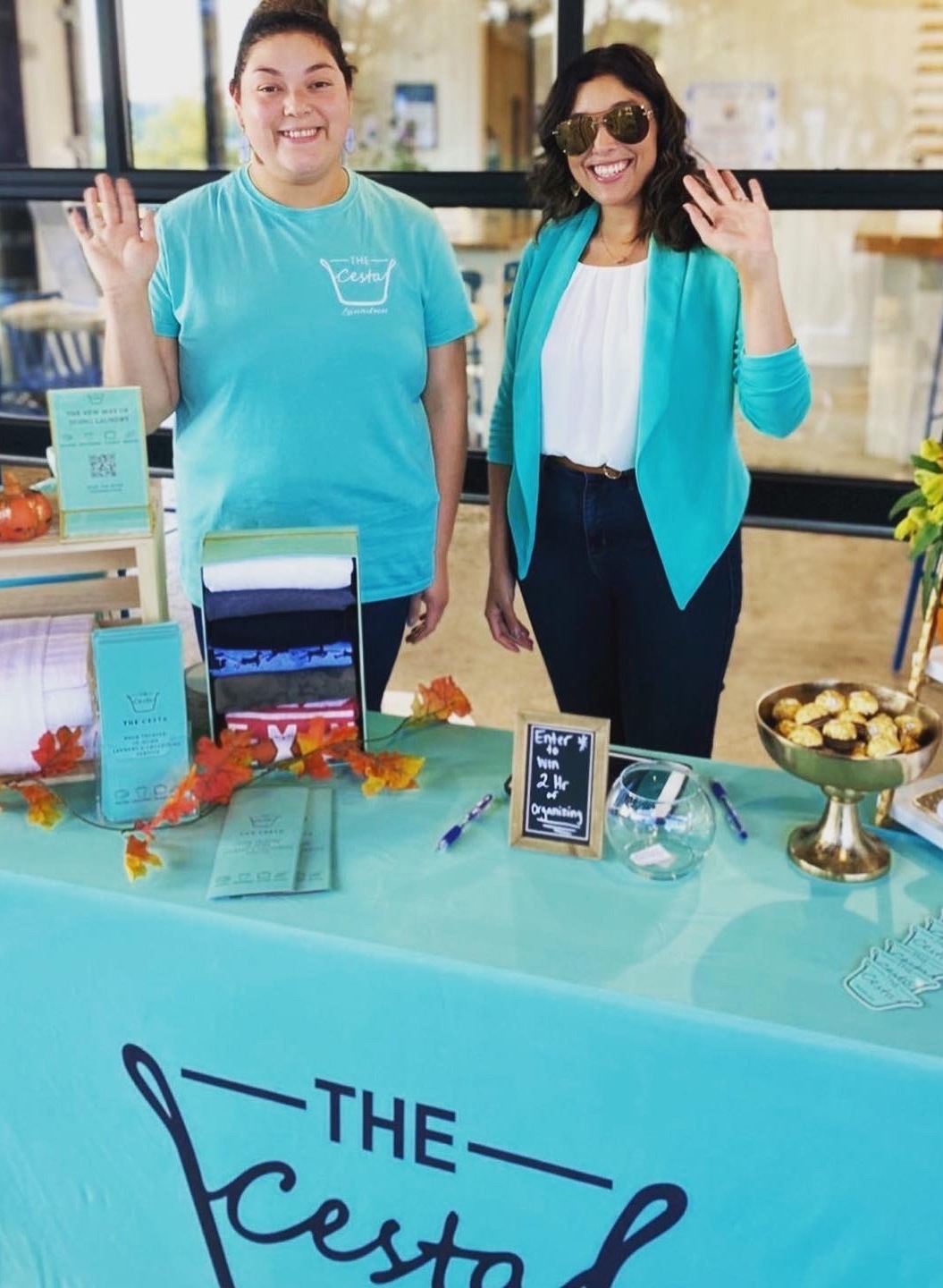 Two Cesta team members greeting guests at a Cesta community event table